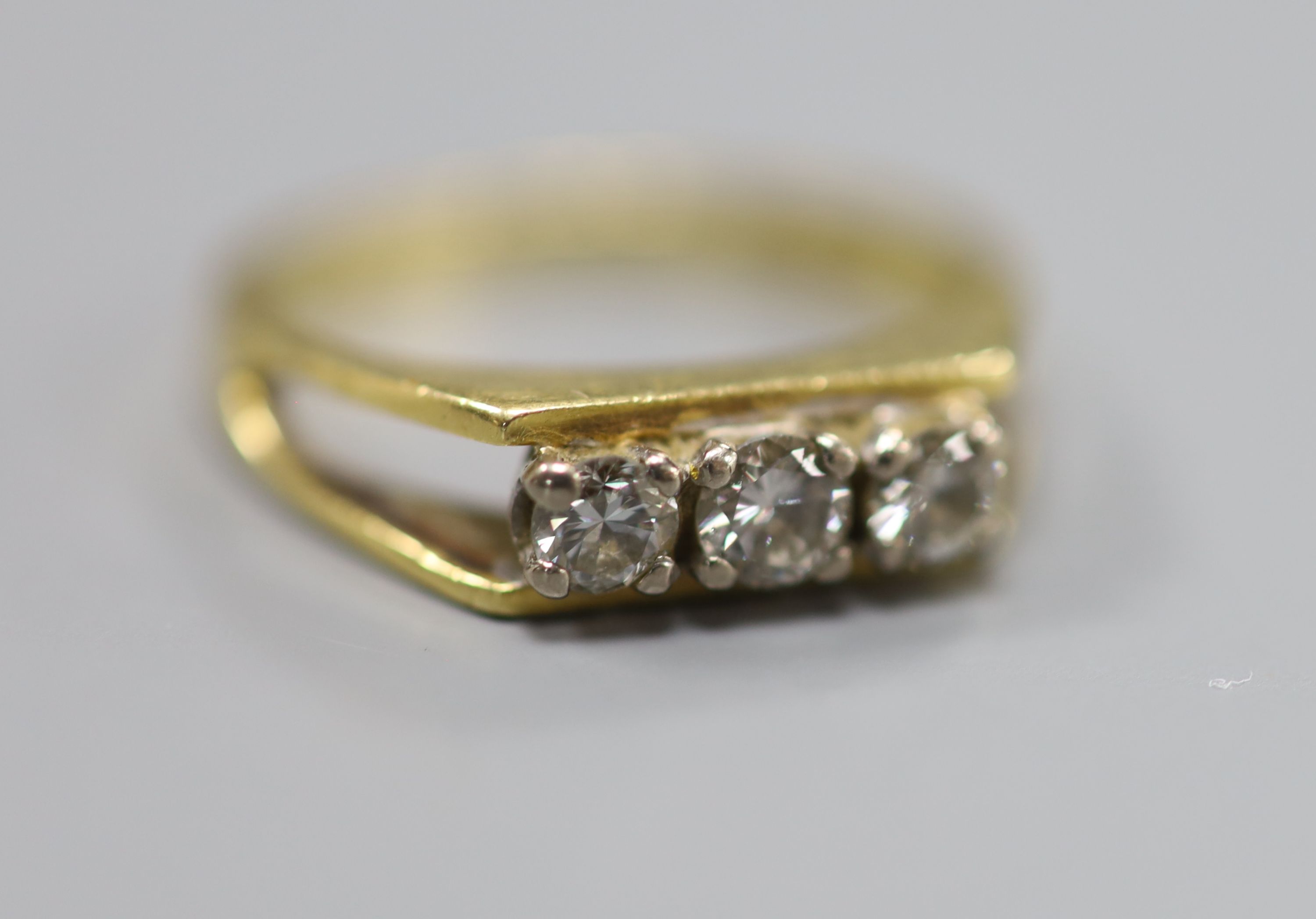A modern 18ct gold and three stone diamond set ring, size K, gross 3.3 grams.
